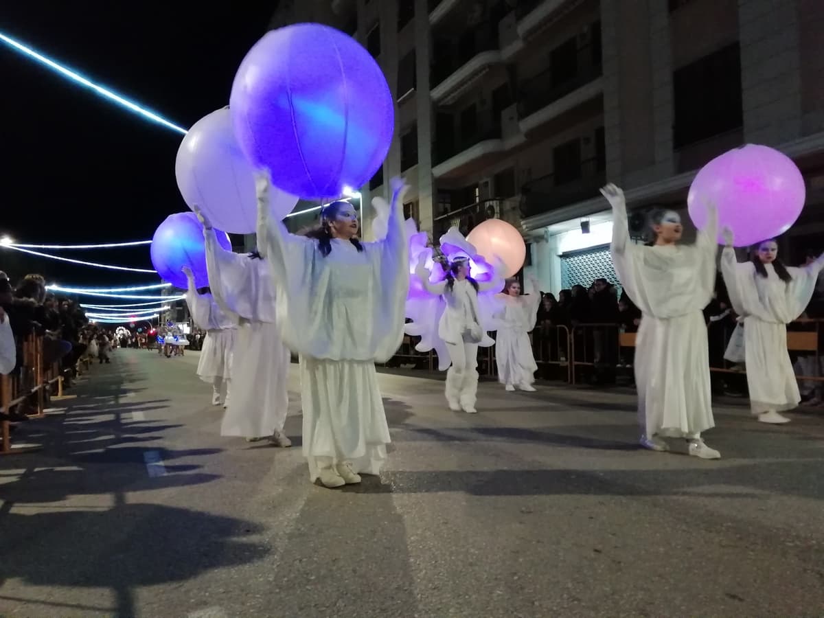 Esferas de luz alzadas por el cortejo durante un pasacalles de luz nocturno