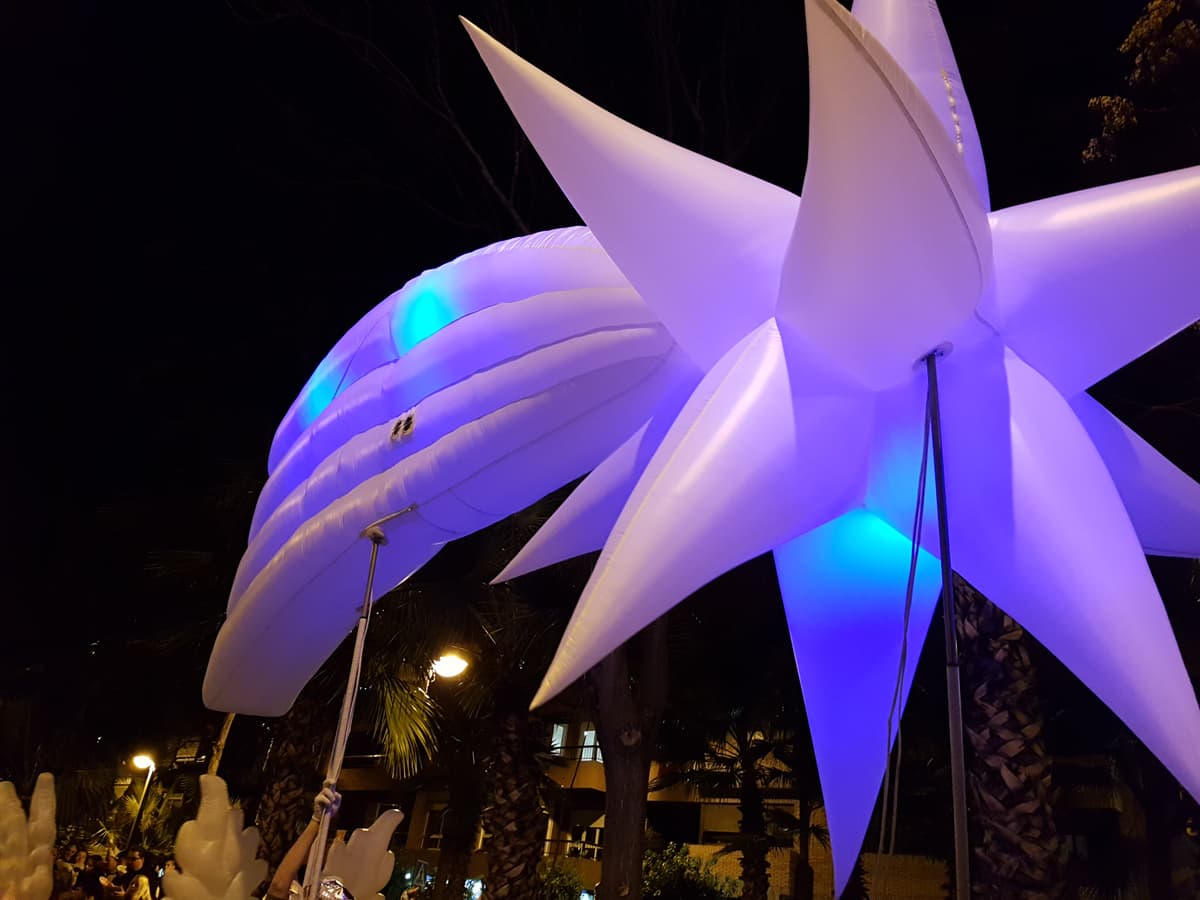 Primer plano de una estrella iluminada en morado y blanco contra el cielo nocturno